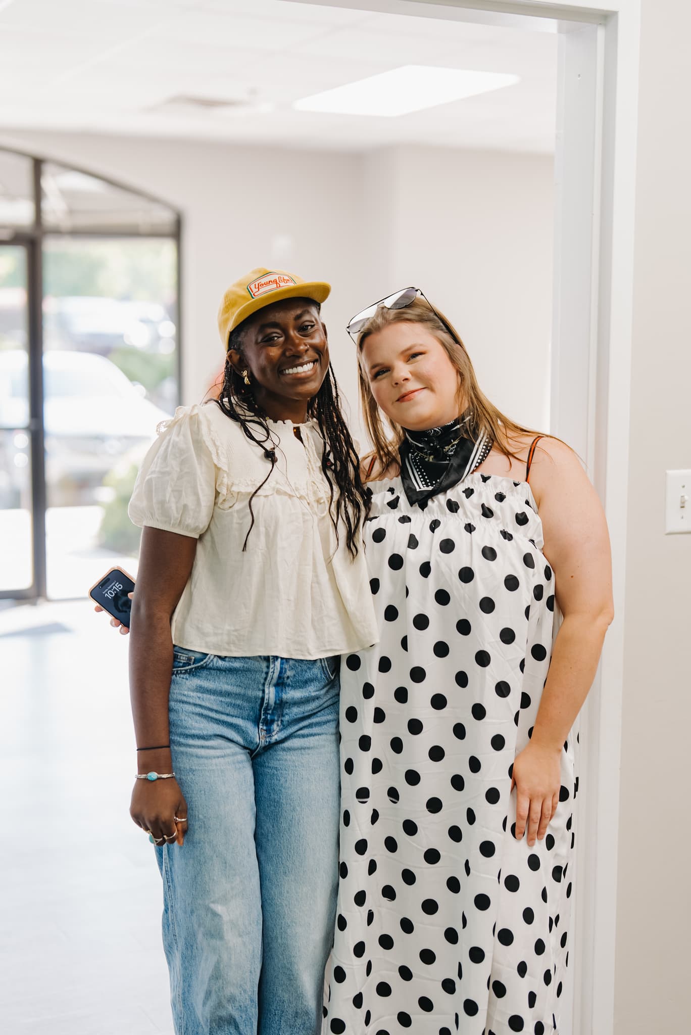 Two friends smiling together in the Brighthouse Church lobby on a Sunday morning
