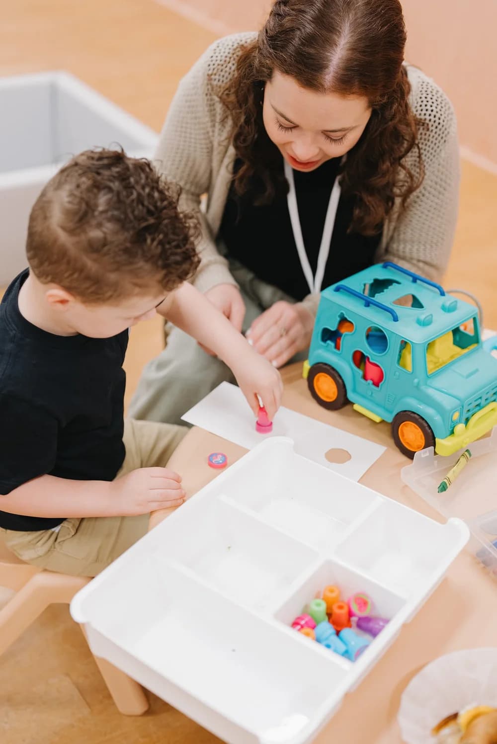 A Brighthouse Kids leader doing a craft activity with a young child
