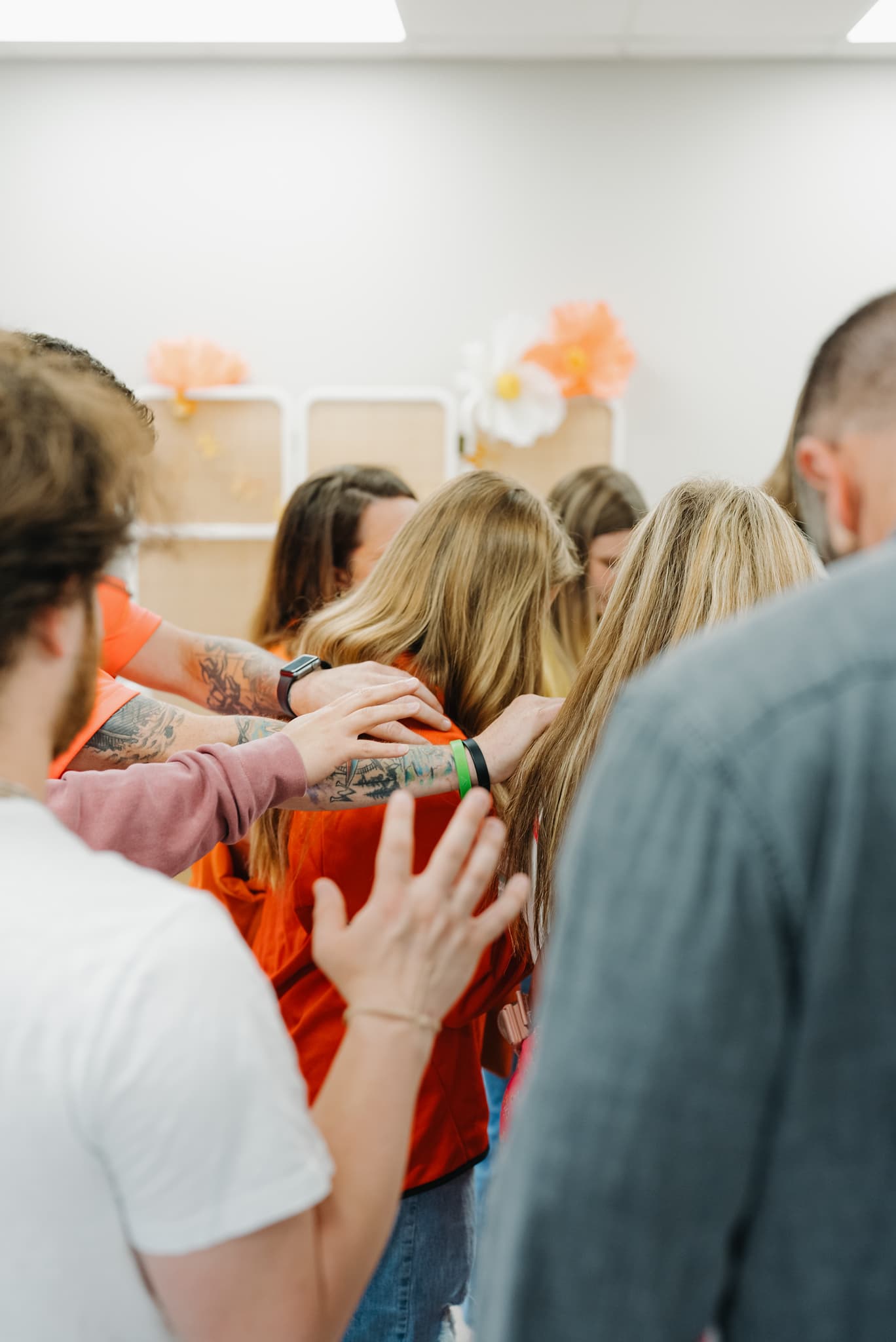 A group of people laying their hands on someone to pray over them at Brighthouse Church