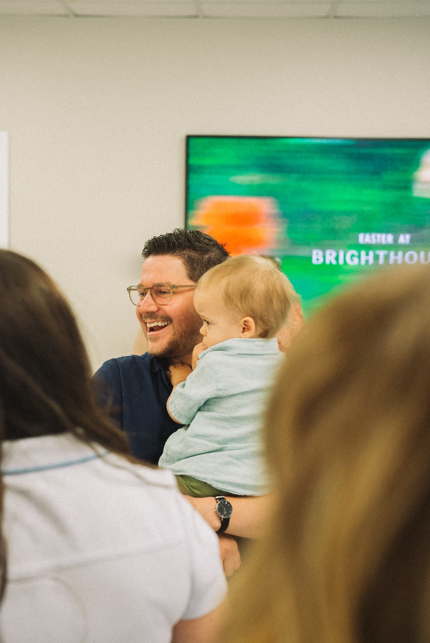 A dad holding his little one during a Sunday gathering at Brighthouse