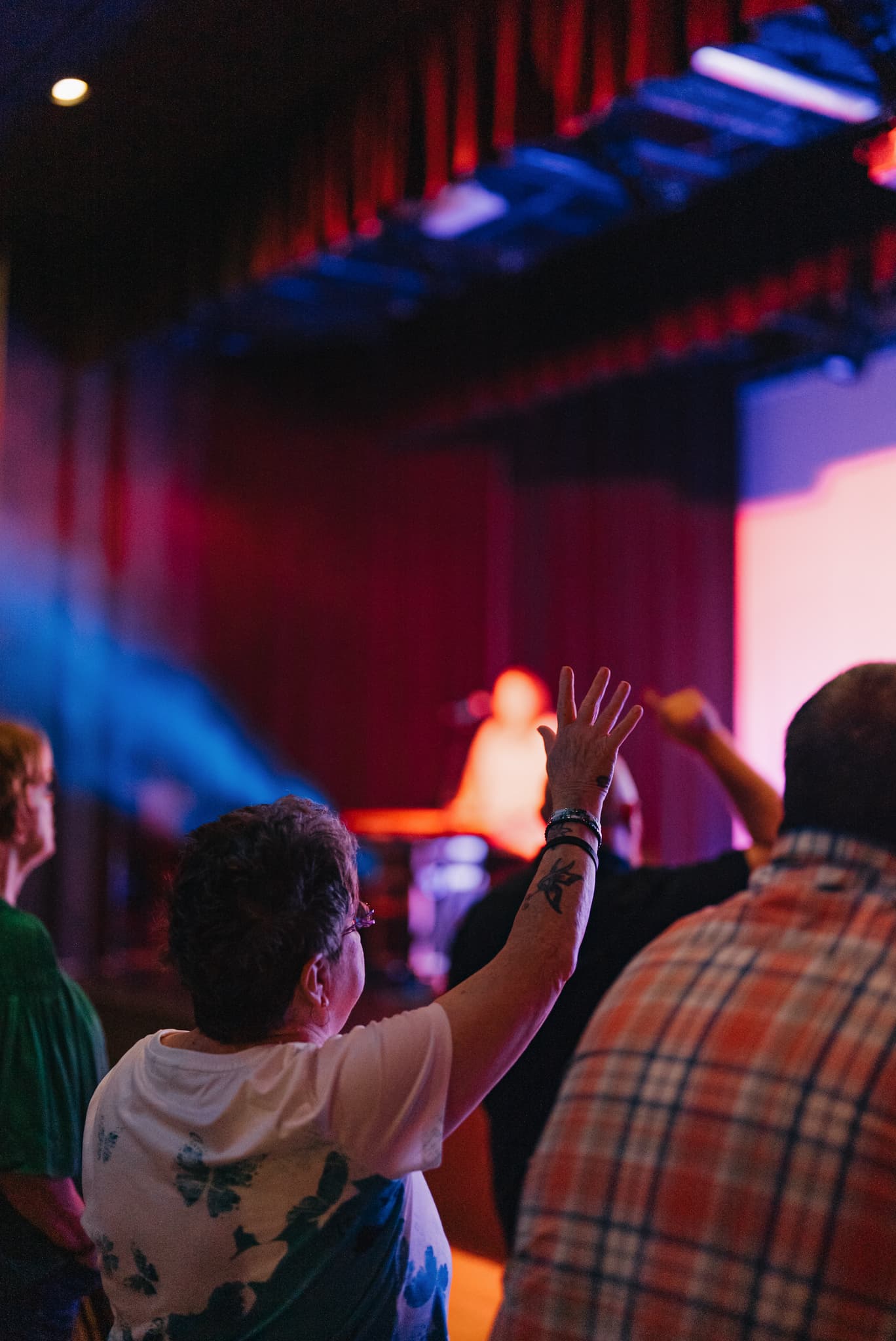 A woman worshiping with her hand raised during a Brighthouse gathering